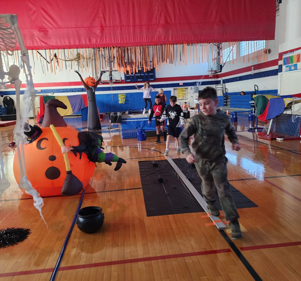 student runs around jack-o-lantersn