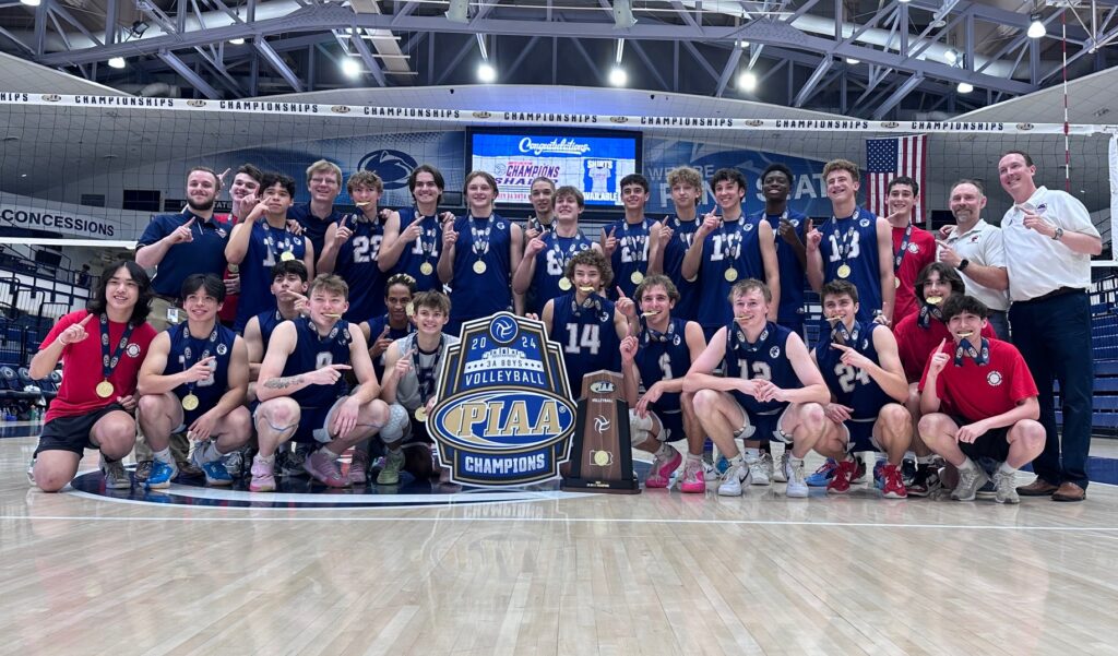 The championship volleyball team pose with their trophy