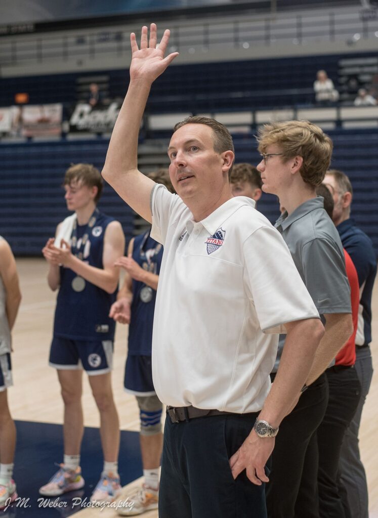 Coach Stadelman waves from on court