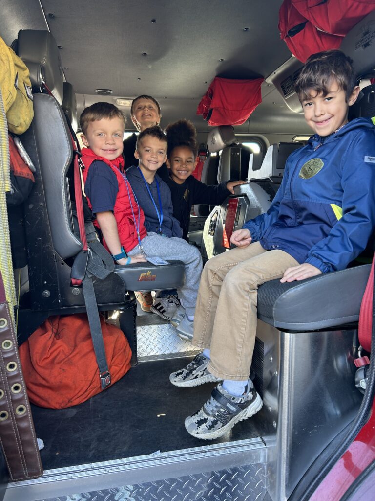 Students smile in a fire truck