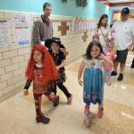 Students stand in hallway in costumes