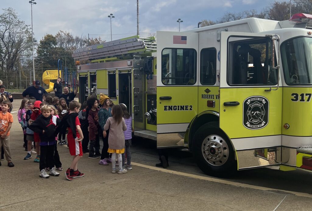 Students look at a yellow fire truck