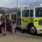 Students look at a yellow fire truck