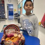 Student stands with the food his mother made