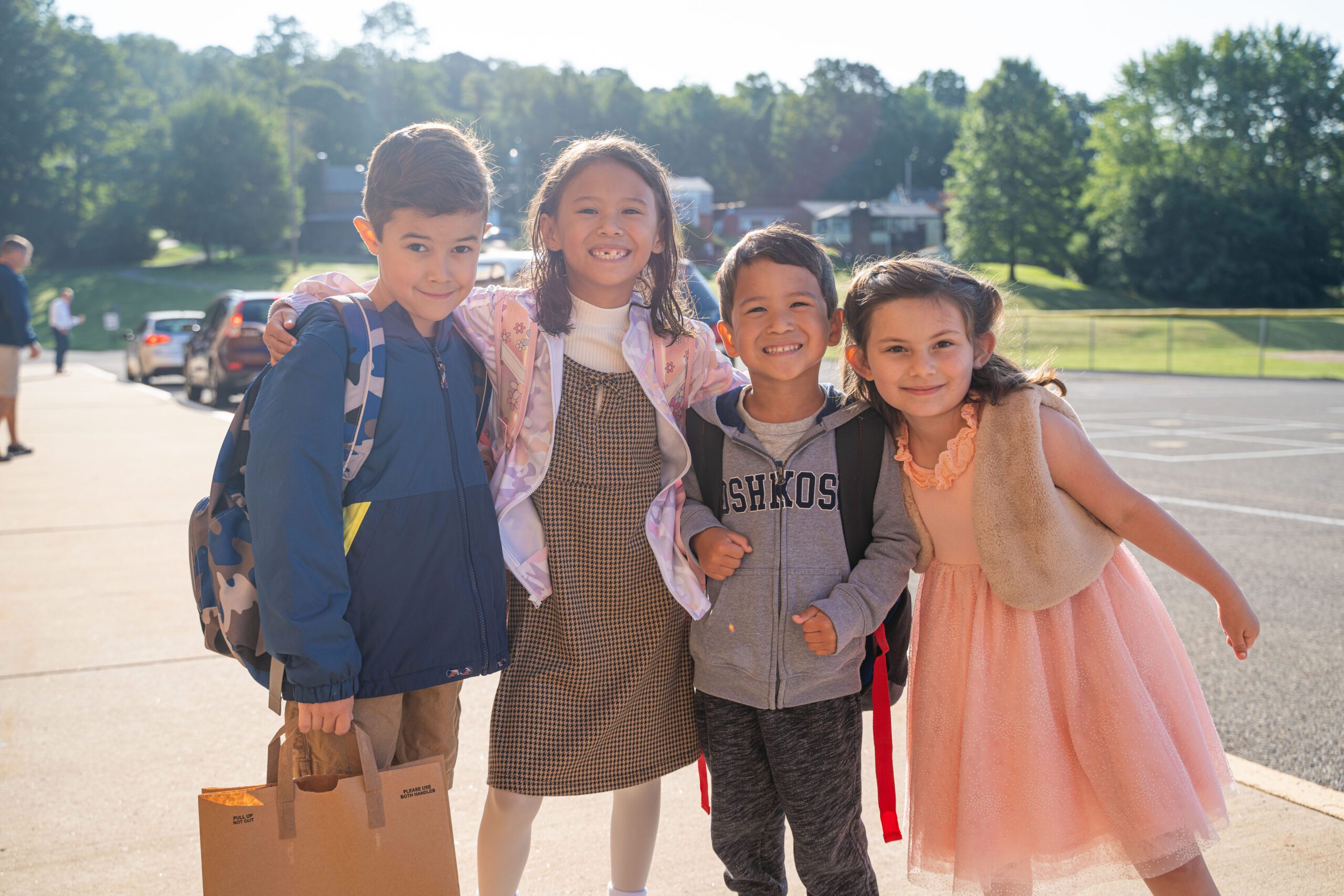 Students smile outside in the sun