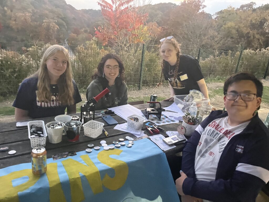 students smile at a table in the park