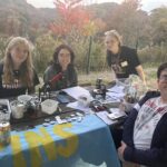 students smile at a table in the park