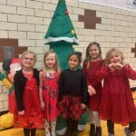 students smile in front of an inflatable tree