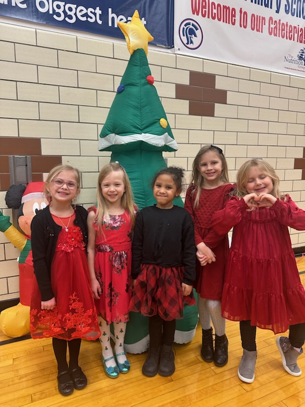 students smile in front of an inflatable tree