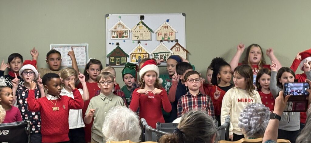 students sing to residents