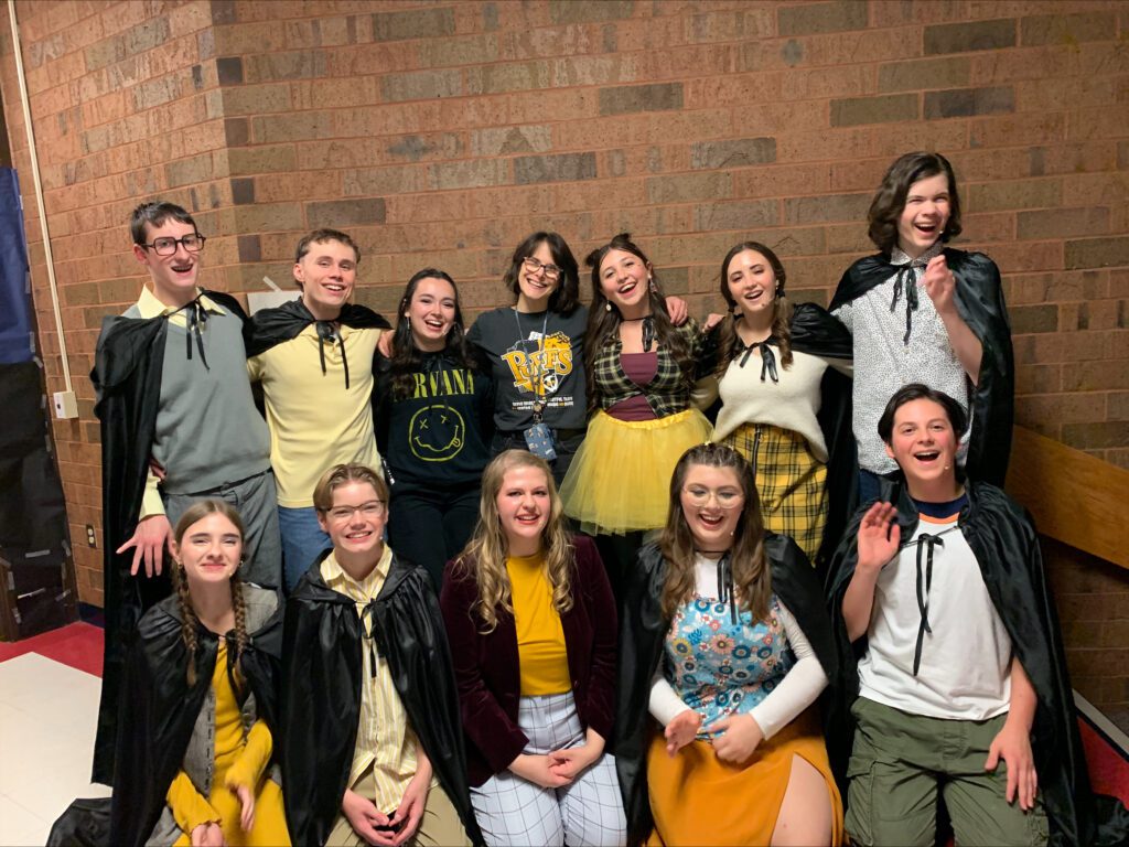 The cast of puffs pose in the high school hallway