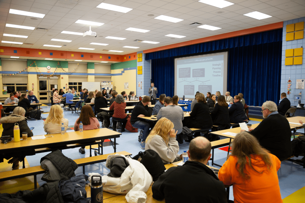 Dr. O'Black addresses the cafeteria full of community members