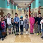 Students dressed as centenarians stand in the hall