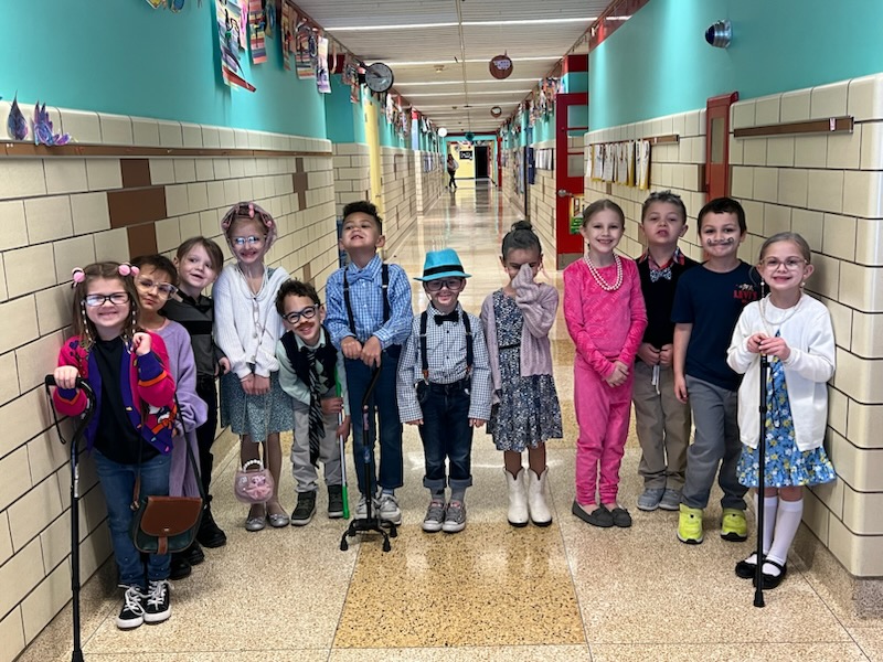 Students dressed as centenarians stand in the hall