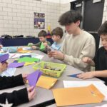 Students practice origami together