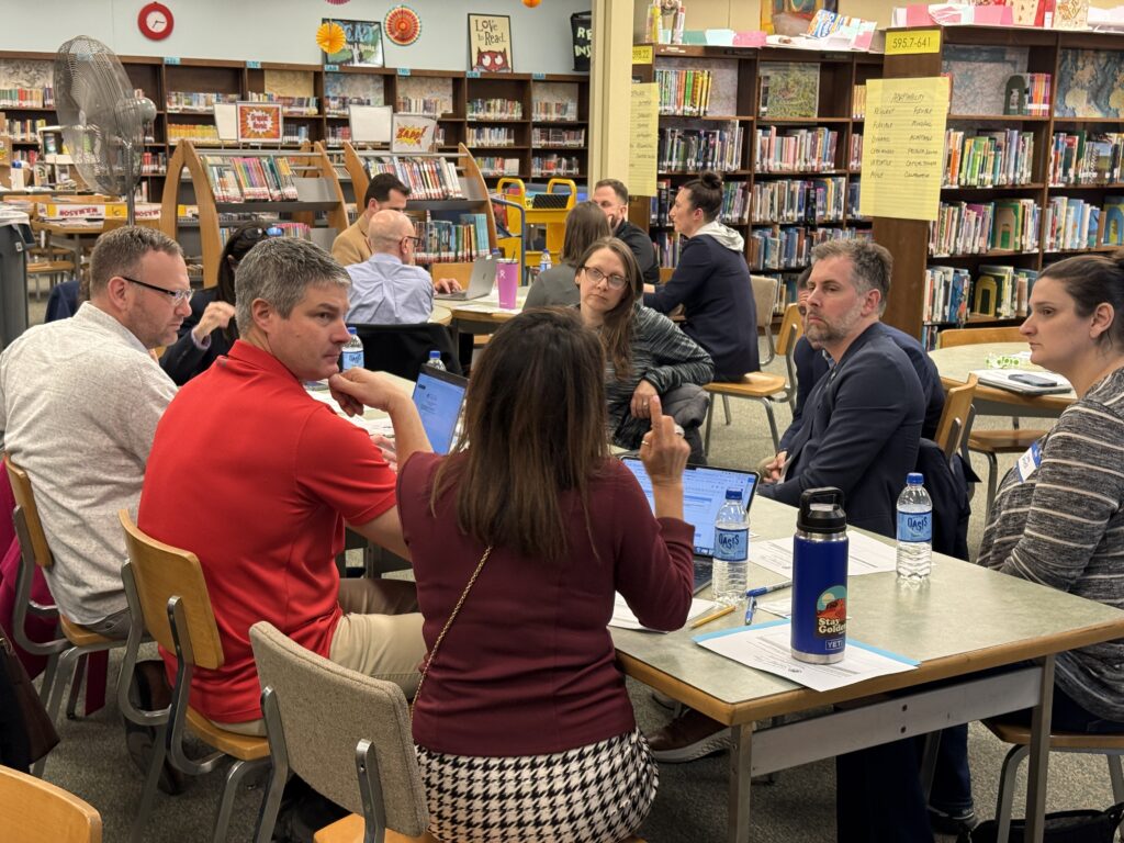 Groups discuss around a table