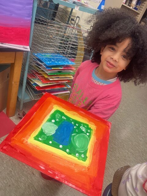 student shows her painting