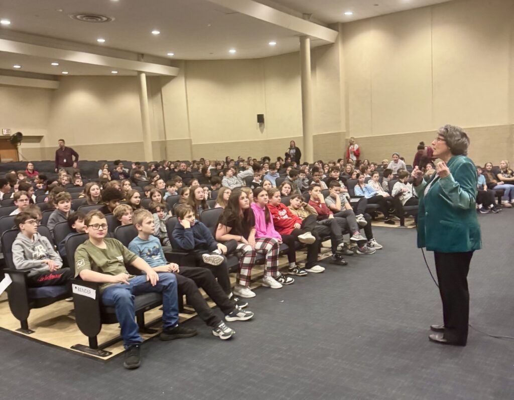 Lynne Ravas addresses an auditorium of students