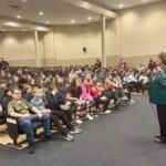 Lynne Ravas addresses an auditorium of students