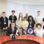 students stand with dignitaries